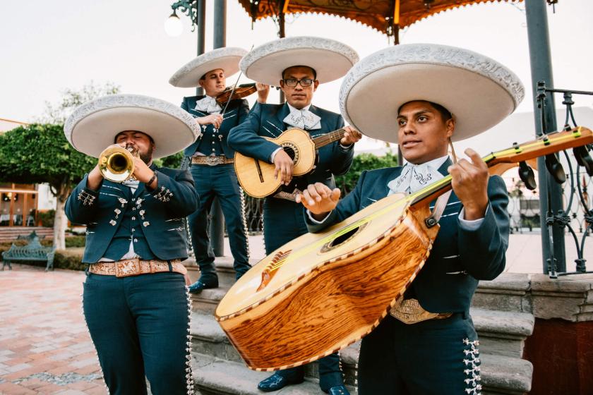 Three mariachis playing music