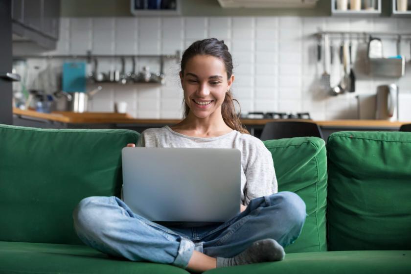 Woman smiling while using laptop.